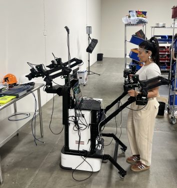 Senior Robot Pilot Sofia Infante operates a leader-follower rig to generate robot training data.